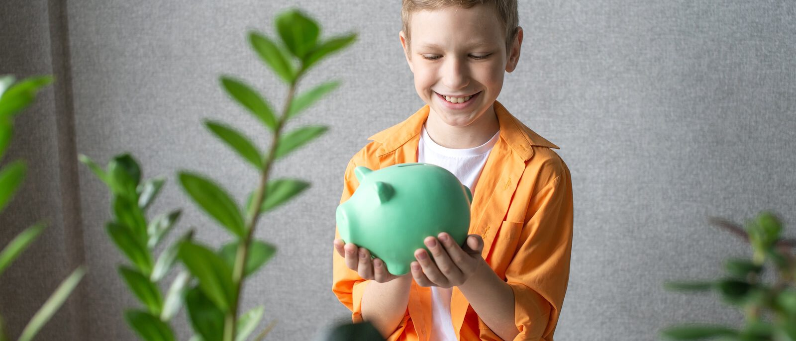 Junge mit Sparschwein spart Geld