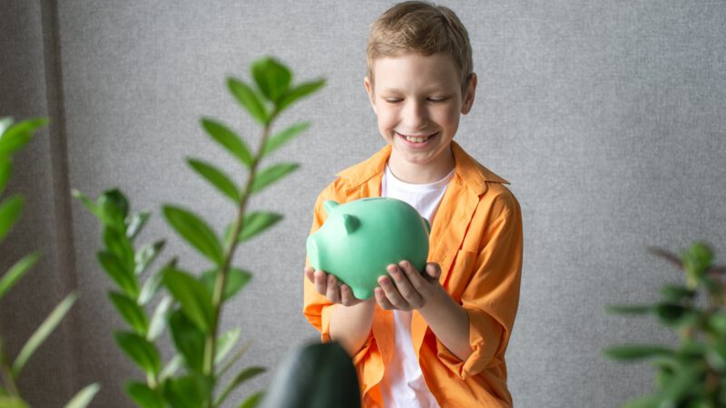 Junge mit Sparschwein spart Geld