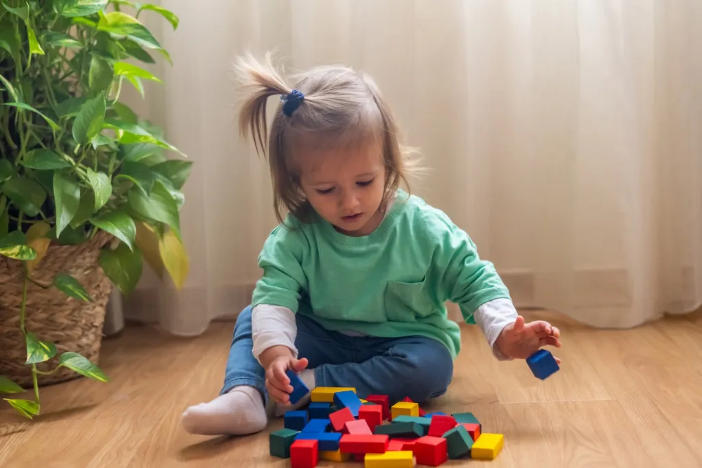 Kleines Mädchen spielt mit Bausteinen