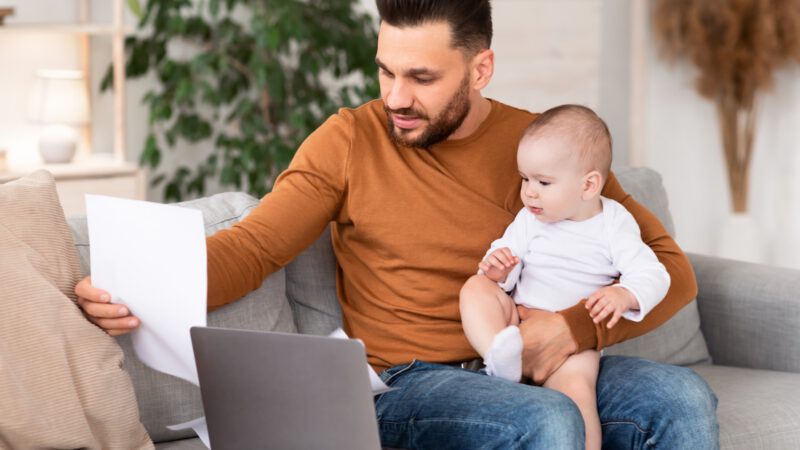 Papa füllt Anträge nach der Geburt am Tablet aus.