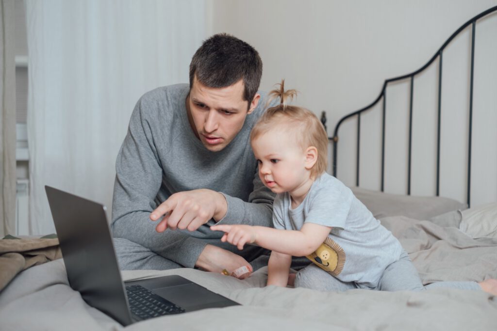 Vater zeigt seinem Kind am PC einen Welt-ETF