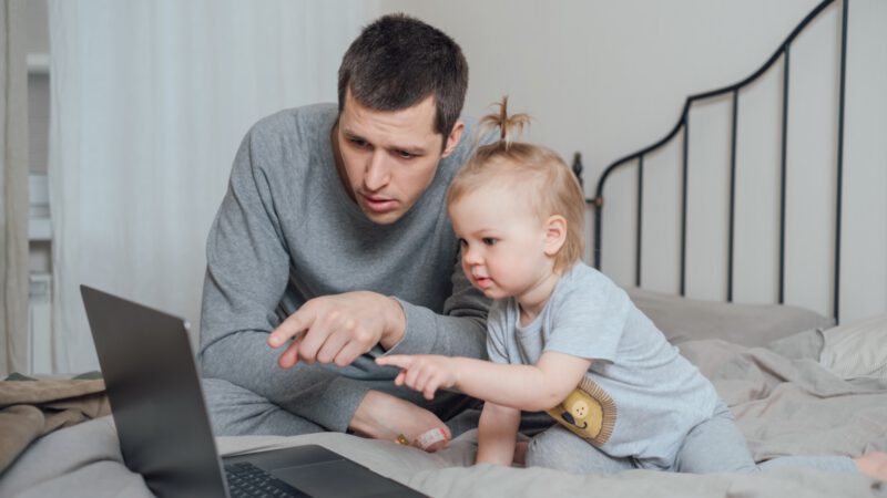 Vater zeigt seinem Kind am PC einen Welt-ETF